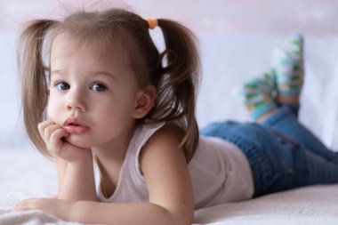 Güzel kız yatakta kalemlerle resim çizer. Küçük kız iki yıl boyunca yatağın üzerine boyama kitabı çizdi. Yatakta yatarken at kuyruklu küçük bebek gülümsüyor. Güzel kız kalemle resim yapıyor ve...