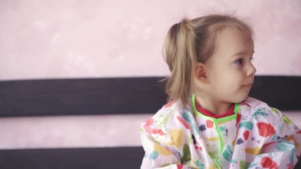 Dziewczynka w wieku 3 lat maluje na kartce papieru. Piękna dziewczyna słowiański wygląd farby siedzi na łóżku — Wideo stockowe
