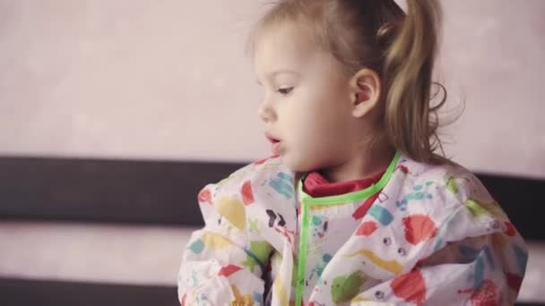 Little girl age 3 draws with crayons on a piece of paper. Beautiful girl of Slavic appearance draws sitting on bed — Stock Video