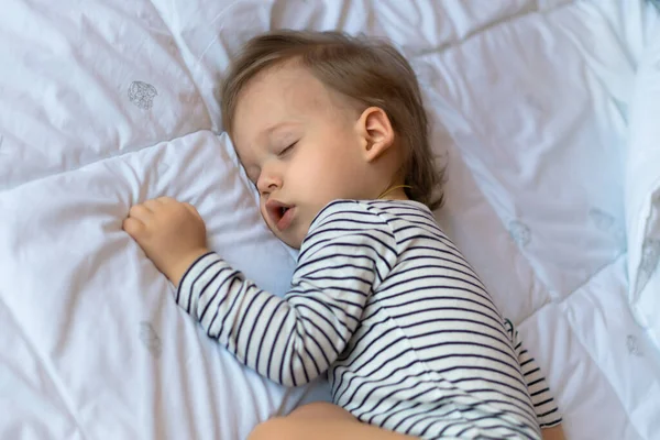Kleine blonde baby slaapt in zijn bed — Stockfoto