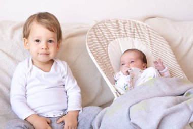 Ağabeyi ve yeni doğmuş kız kardeşi. Ağabeyi yeni doğan bebekle oynuyor..