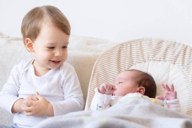 Ağabeyi ve yeni doğmuş kız kardeşi. Ağabeyi yeni doğan bebekle oynuyor..