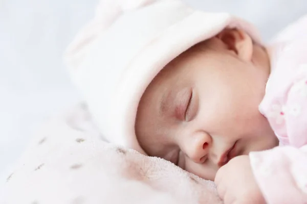 Adorable bebé recién nacido durmiendo boca abajo sobre una manta suave. Un bebé recién nacido en un sombrero duerme sobre una manta suave —  Fotos de Stock