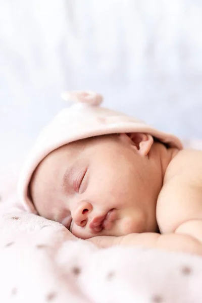 Adorável bebê recém-nascido dormindo no estômago em um cobertor macio. Um bebê recém-nascido em um chapéu dorme em um cobertor macio — Fotografia de Stock