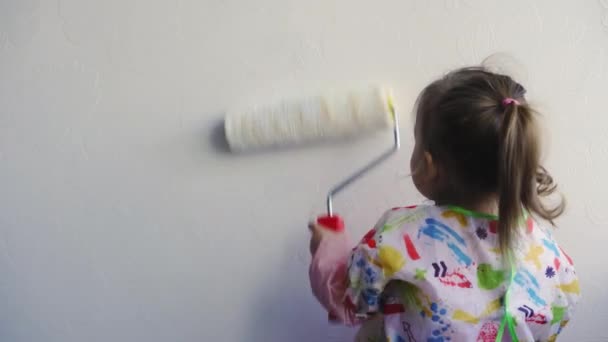 Repair, construction, home, family, childhood, parenthood, fatherhood, self-isolation, quarantine concept - close-up little 3-year-old girl playing with paint roller, painted on white, copy spase. — Stock Video