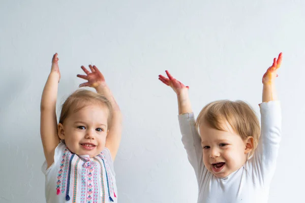 Painting is fun for kids - happy children play with dirty hands. Brother and sister playing with hands in the colorful painting. Children raise their hands up — Stock Photo, Image