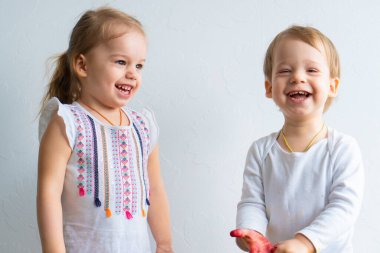 Resim çocuklar için eğlencelidir. Mutlu çocuklar kirli ellerle boyayla oynar. Erkek ve kız kardeş renkli resimde ellerle oynuyorlar. Çocuklar farklı duygular gösterir.