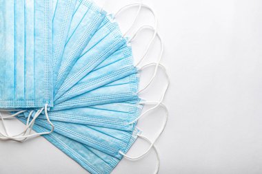 Birkaç tıbbi mavi kullan-at koruyucu maske üst üste beyaz arka planda vantilatör şeklinde. Cerrahi giysi ağız ve burnu kapatır. Sağlık, ilaç, covid-19, salgın konsepti..