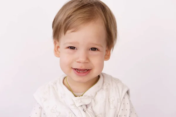 Een jongetje van 2 jaar in een slaapzak op het bed. Een knappe jongen in pyjama zit op het bed en lacht. Concept van zoete dromen, familie, jeugd en thuis — Stockfoto