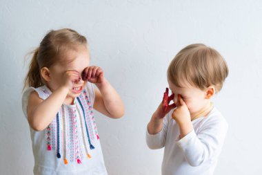 Resim çocuklar için eğlencelidir. Mutlu çocuklar kirli ellerle boyayla oynar. Erkek ve kız kardeş renkli resimde ellerle oynuyorlar. Çocuklar farklı duygular gösterir.