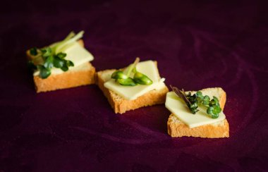 Mor arka planda tereyağlı ve otlu kanepeler