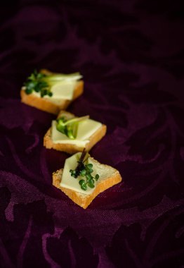 Mor arka planda tereyağlı ve otlu kanepeler