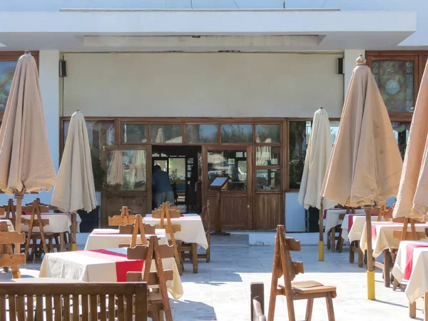 Kapalı şemsiyeli bir sahil restoranı. Ziyaretçi yok - boş masalar