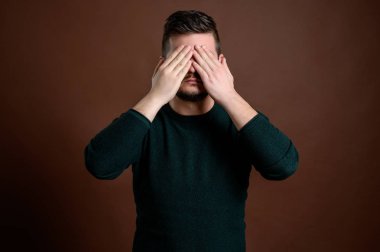 Kahverengi sembollü genç adam üç bilge maymunu simgeliyor.