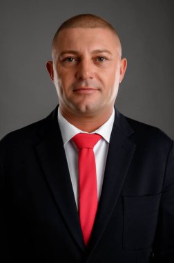 Siyah takım elbiseli ve kırmızı kravatlı bir iş adamı.