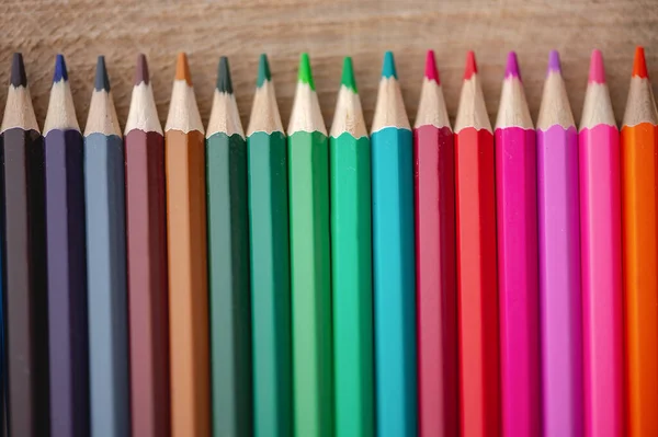 天然木材背景上彩虹色铅笔的特写 — 图库照片