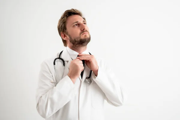 Férfi Orvos Sztetoszkópos Portréja Orvosi Egyenruhában Elrendezi Nyakkendőjét Fehér Elszigetelt — Stock Fotó