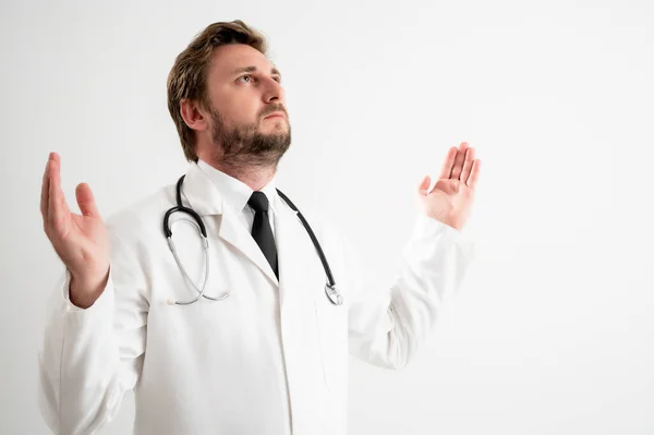 男性医師の肖像とともに聴診器で医療制服を着て腕を上に見上げます サイドビューは 白い隔離された背景にポーズ — ストック写真