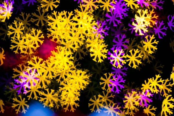 Resumen Amarillo púrpura luces copo de nieve bokeh fondo — Foto de Stock
