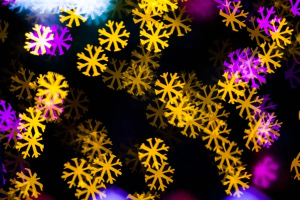 Žlutá fialová světla sněhová vločka bokeh pozadí abstraktní — Stock fotografie