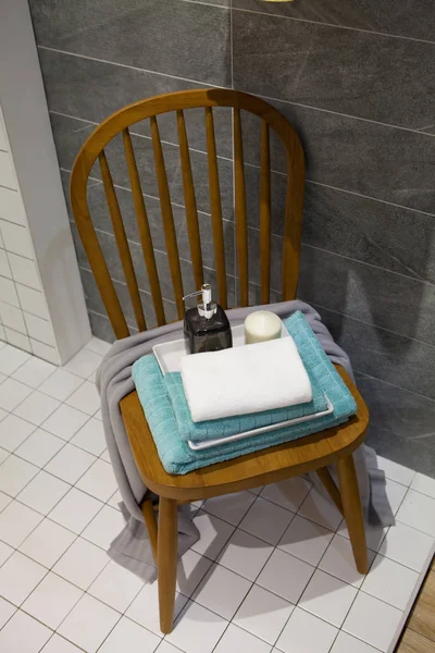 Bouteille de savon liquide et bougie avec serviettes sur chaise Acce salle de bain — Photo