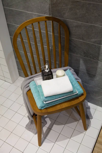 Bouteille de savon liquide et bougie avec serviettes sur chaise Acce salle de bain — Photo