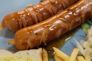 Izgara sosis sosu ve taze salata ve patates kızartması ile