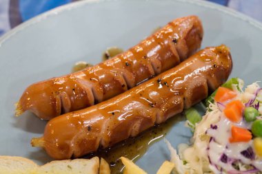 Izgara sosis sosu ve taze salata ve patates kızartması ile