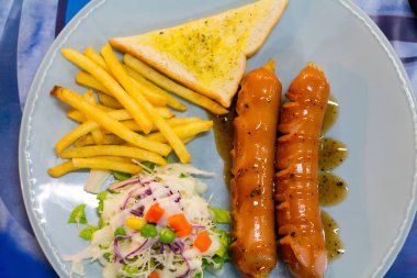 Izgara sosis sosu ve taze salata ve patates kızartması ile 