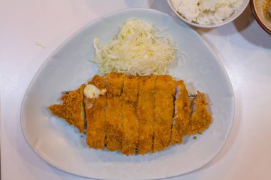 Kızarmış pirzola domuz (Tonkatsu: Japanses gıdalar) lahana ile beyaz plaka üzerinde