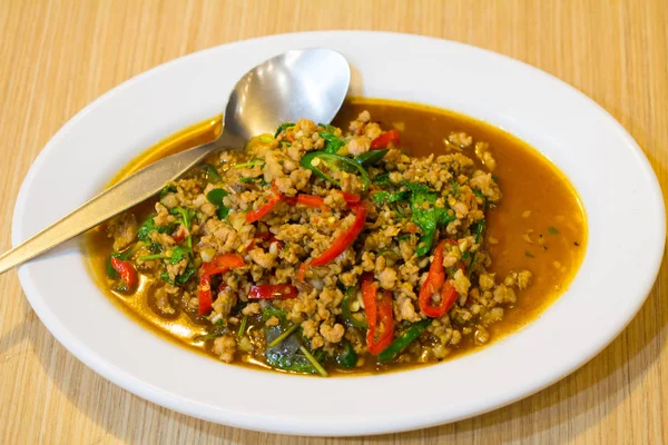 Beyaz tabakta domuz kıyması ve fesleğenle kızartılmış. (Ka Prao Moo)