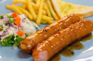 Izgara sosis sosu ve taze salata ve patates kızartması ile