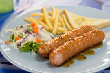 Izgara sosis sosu ve taze salata ve patates kızartması ile