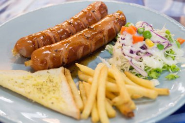 Izgara sosis sosu ve taze salata ve patates kızartması ile