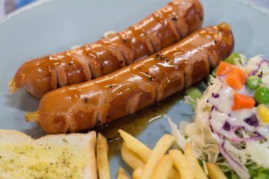 Izgara sosis sosu ve taze salata ve patates kızartması ile