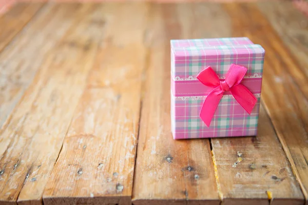 Scatola regalo rosa su sfondo in legno con spazio — Foto Stock