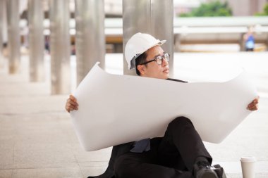 Blueprint tasarım seyir siyah montlu erkek mühendis oturan 