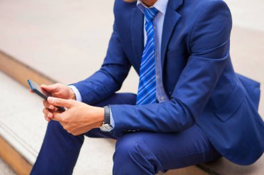 Basamakta callling sırasında telefon ile kapalı oturan işadamı