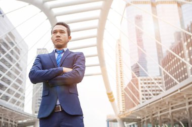 Bir kol, ofis binası ile çapraz ile ayakta işadamı