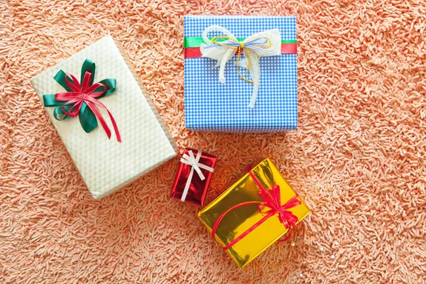 Ornamenti natalizi e scatola regalo su sfondo tappeto. Buon Chr. — Foto Stock