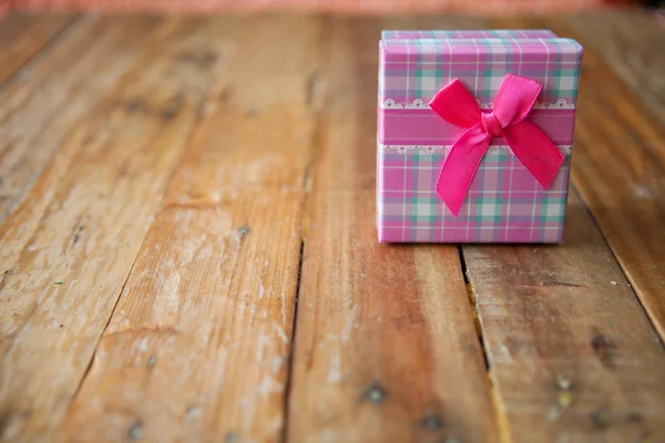Scatola regalo rosa su sfondo in legno con spazio — Foto Stock