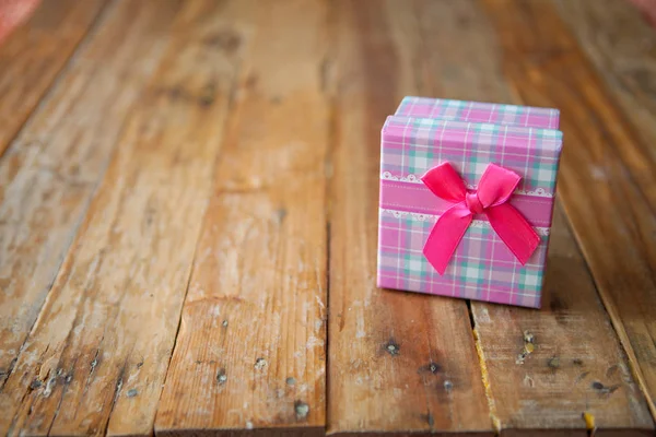 Scatola regalo rosa su sfondo in legno con spazio — Foto Stock