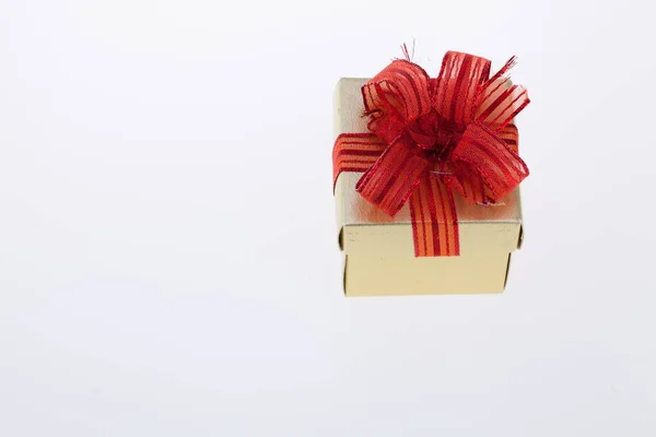Χρυσό δώρο κουτί με κόκκινη κορδέλα απομονωθεί σε λευκό — Φωτογραφία Αρχείου