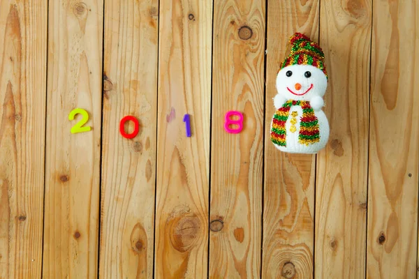 2018 colorful alphabet and snow man on wooden plank background