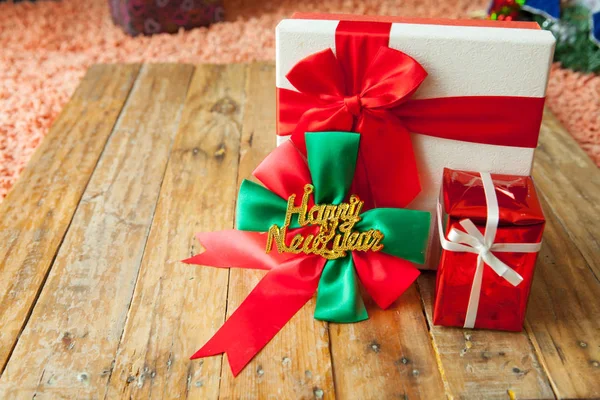 Caja de regalo blanca y cinta roja sobre fondo de madera con espacio — Foto de Stock