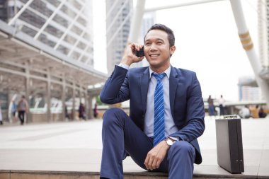 Basamakta callling sırasında telefon ile kapalı oturan işadamı