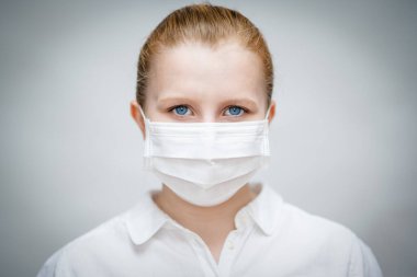 Tıbbi maskeli, genç ve çekici bir kadın. Virüs ve bakterilere karşı korunma Covid-19 Coronavirus. Beyaz arkaplanın önünde