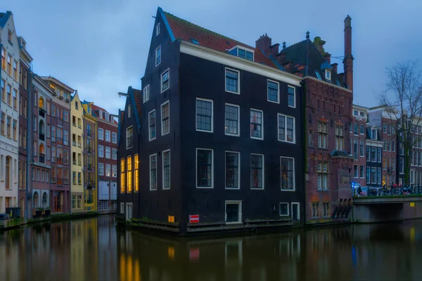 Hollanda 'nın mavi saatinde Amsterdam' da bir kanalda mavi bir ev.