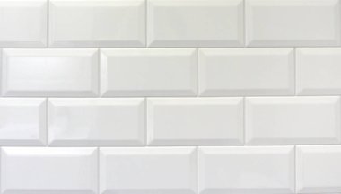 Banyodaki bir duvarda beyaz dikdörtgen parlak fayans.