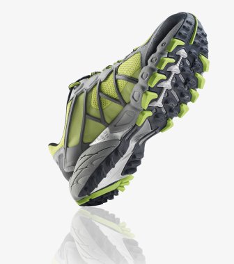 Yeşil ve gri rahat spor ayakkabıları, beyaz arka plana yaslanmış kauçuk tabanlı.